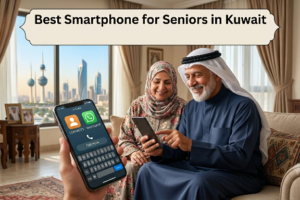 ​An elderly Arab couple sitting on a sofa in a living room, smiling while looking at a smartphone, with a close-up of a mobile screen showing large icons and a text banner reading "Best Smartphone for Seniors in Kuwait" against the backdrop of the Kuwait Towers visible through the window