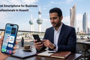 ​A professional businessman in a blue suit using a smartphone at an outdoor cafe table in Kuwait City, with the Kuwait Towers visible in the background. In the foreground, another hand holds a mobile phone displaying business apps, featuring the text Best Smartphone for Business Professionals in Kuwait